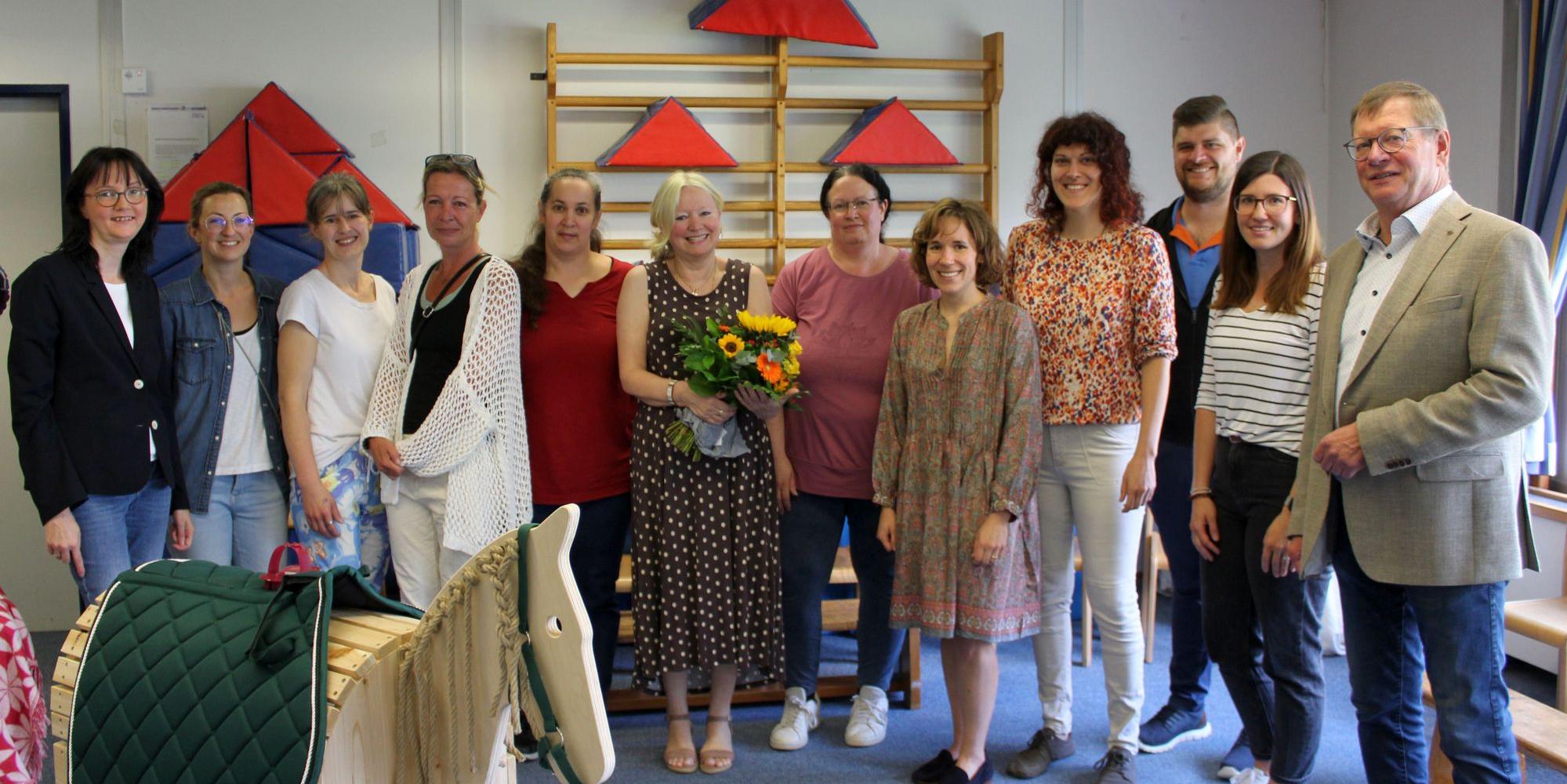 Gruppenbild mit Frau Monika Hohn, die einen Blumenstrauß hält, Bürgemeister Martin Lerbs und zehn weiteren Kolleg:innen