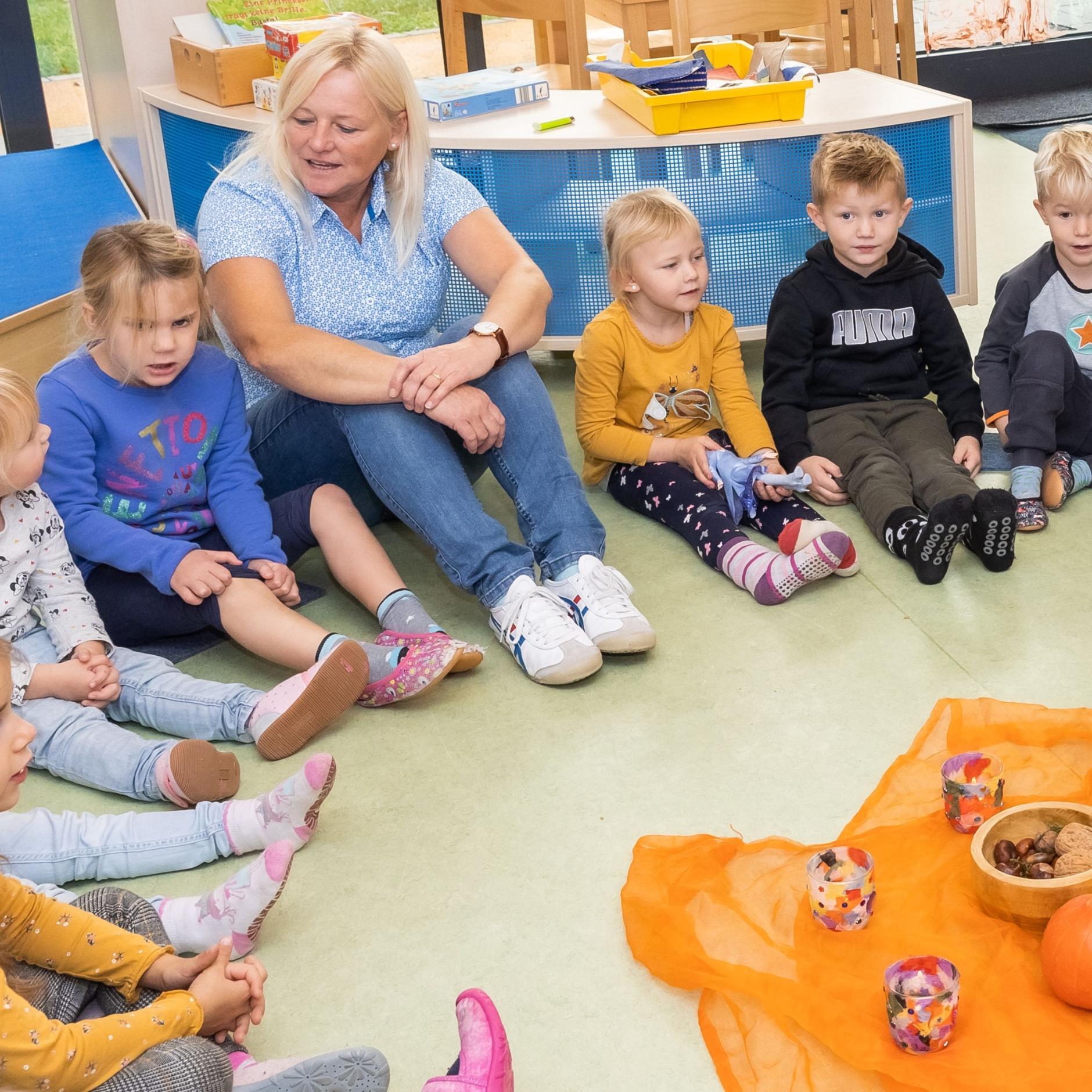 Kinder sitzen gemeinsam mit einer bloden Erzieherin im Morgenkreis