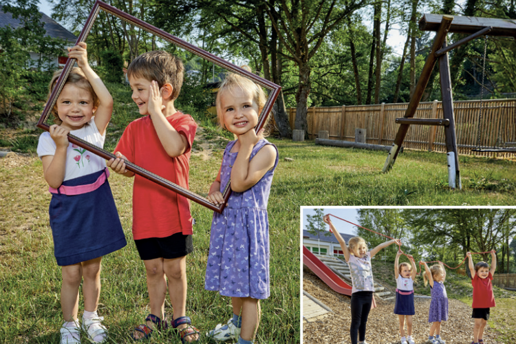 Kinder die im Sommer mit einem Bilderrahmen auf einem Spielplatz stehen